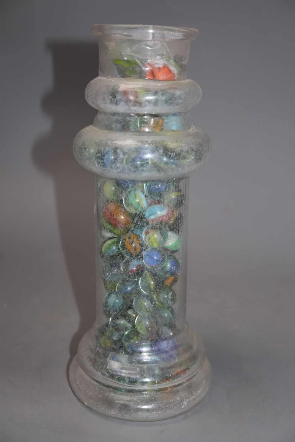 A Victorian glass vase, containing a collection of Victorian and later coloured marbles, height 27cm